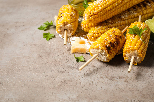 Delicious grilled corn cobs on grey table. Space for text - Photo, image