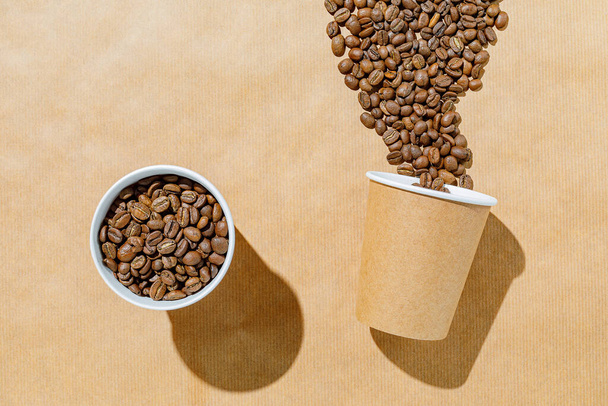tasses en papier jetables et grains de café sur fond de papier jetable - Photo, image