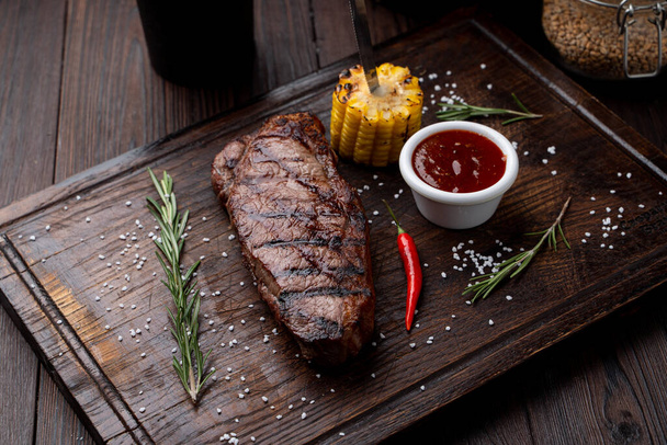 Tenderloin steak with no side dish on a dark wooden board - Valokuva, kuva