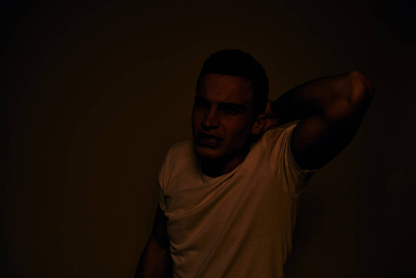 Эмоциональный мужчина жестикулирует руками неудовольствие белой футболки светлый фон - Фото, изображение