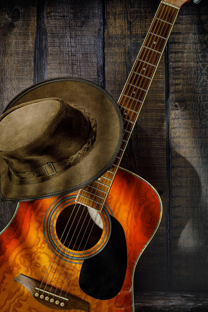 gitara akustyczna i kapelusz kowbojski na drewnianym tle - Zdjęcie, obraz