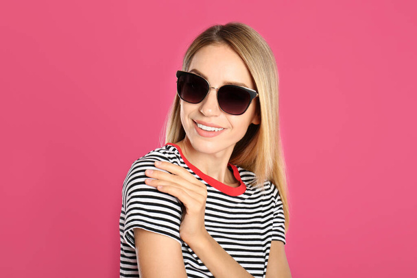 Beautiful woman in stylish sunglasses on pink background - Foto, afbeelding