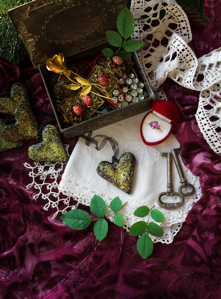 Retro style still life with hearts, ring, lace and golden rose on jewelry box on purple velvet background - Valokuva, kuva