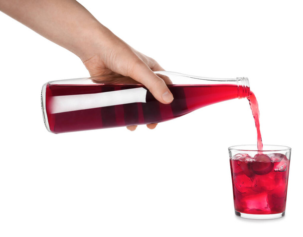 Woman pouring grape soda water into glass on white background, closeup. Refreshing drink - Zdjęcie, obraz