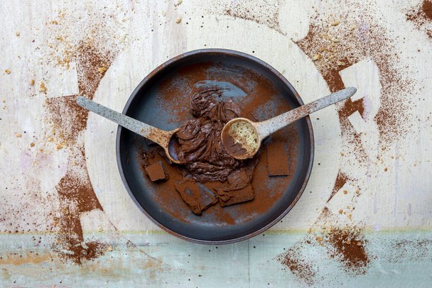hazelnut cocoa cream and chocolate pieces mixed in a bowl on a light wood background. top view - Foto, immagini
