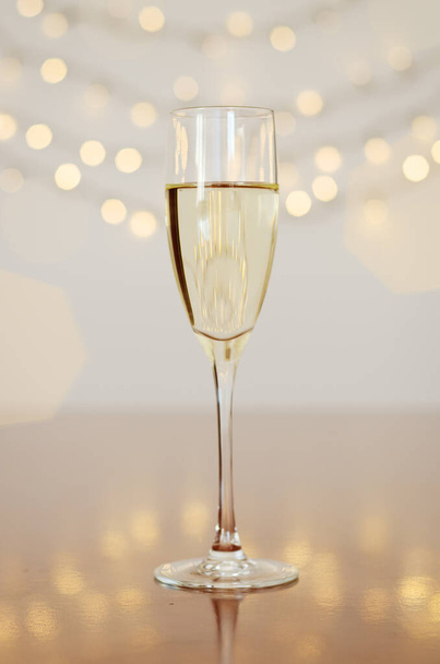Glass of wine with bokeh background close up. Flat lay. New Year, Christmas mood. Greeting card. Party and holiday celebration concept. - Photo, Image