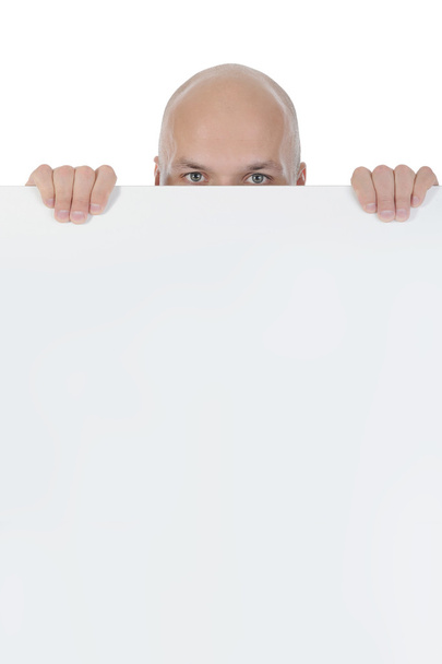 Young bald man holding large blank. - Foto, afbeelding