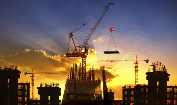 Big crane and building construction against beautiful dusky sky - Photo, Image