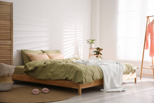 Duże łóżko z miękkim kocem w stylowym wnętrzu pokoju - Zdjęcie, obraz