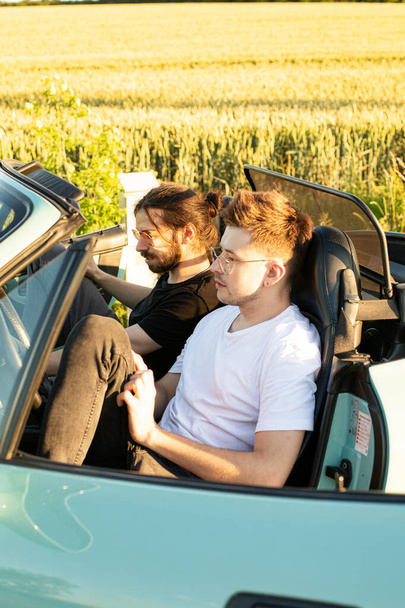 Young white models men sitting in the car - Foto, imagen