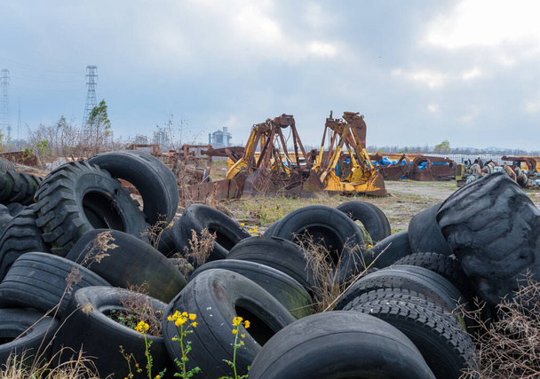 Teollisuuden hautausmaa poisheitetyillä suurilla renkailla ja raskaan kaluston kiinnityksillä Mississippi-joen varrella - Valokuva, kuva