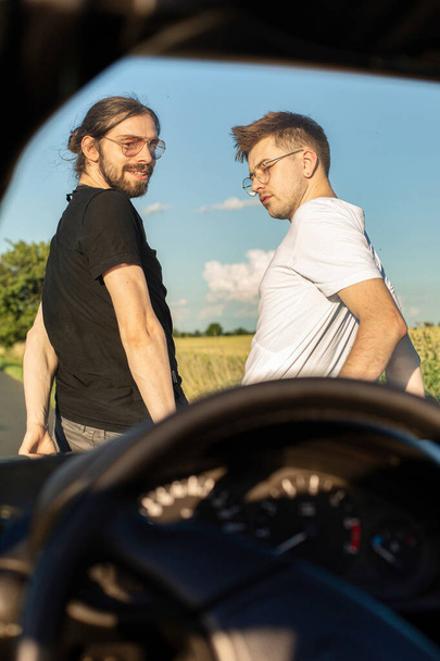 European boys in t-shirts outside through the windshield of car - Foto, Imagem