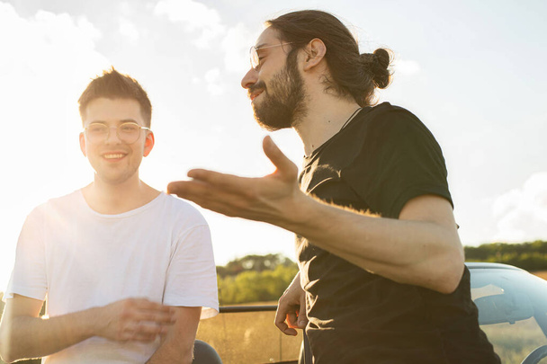 European young white men in t-shirts talking outside - Fotoğraf, Görsel