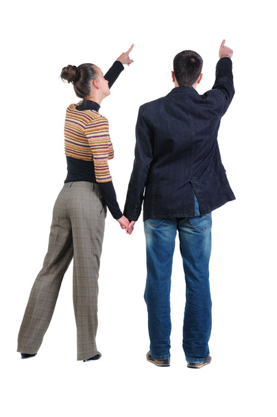 Young couple pointing at wall. Rear view. - Foto, immagini