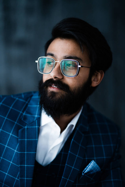 Portrait of a Hindu with glasses with black hair and a beard in a white shirt looking to the side - Foto, Imagen
