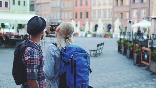 Şehir merkezinde akıllı telefondan selfie çeken genç turistlerin arka görüntüsü. - Fotoğraf, Görsel