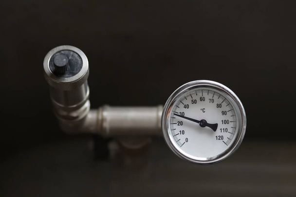 A fűtési rendszerben a víz hőmérsékletének mérésére szolgáló eszköz. Csőnyomáshatároló szelep. - Fotó, kép