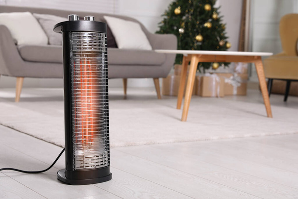 Modern electric heater on floor at home. Space for text - Zdjęcie, obraz