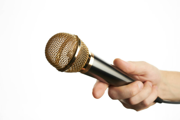 uomo tiene microfono dorato isolato su uno sfondo bianco. Concetto intervista. per la progettazione o la decorazione - Foto, immagini