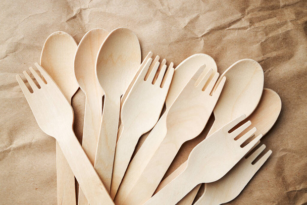 eco friendly disposable kitchenware utensils on paper background. look from above. wooden forks and spoons. eco friendly concept - Fotoğraf, Görsel