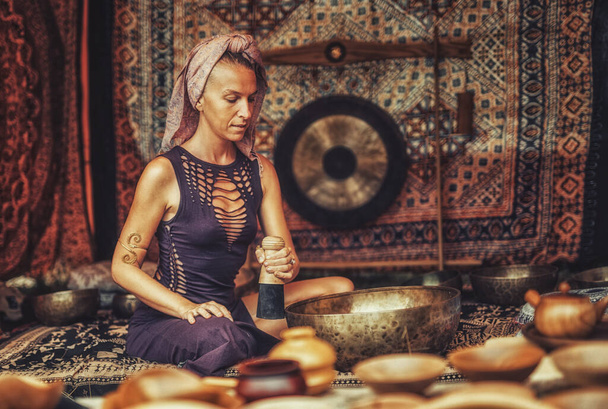 Spiritual girl immersed in meditative sounds of tibetian bowl. - Photo, Image