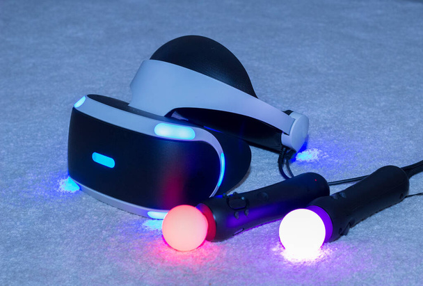 Virtual reality equipment. Glasses and joysticks glow in the dark. - Фото, изображение