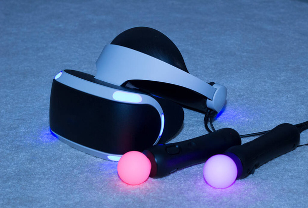 Virtual reality equipment. Glasses and joysticks glow in the dark. - Photo, image
