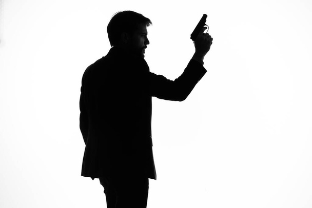 schaduw van een man met een pistool in zijn handen gericht op zelfmoord gevaar - Foto, afbeelding