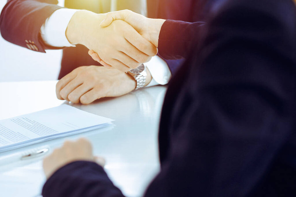Businesspeople or lawyers shaking hands finishing up meeting or negotiation in sunny office. Business handshake and partnership - Photo, Image