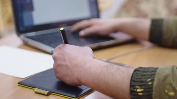 Πλευρική άποψη του ανθρώπου σχεδιάζει και εργάζεται σε έναν υπολογιστή χρησιμοποιώντας ένα tablet γραφικών - Πλάνα, βίντεο