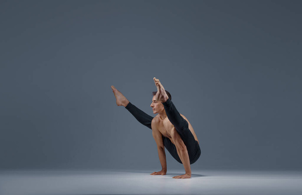 Чоловіча йога робить шпагат розділений на руки
 - Фото, зображення