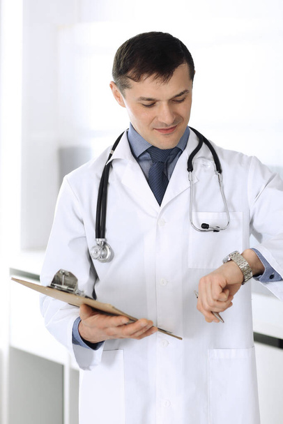 Doctor man using clipboard for filling up medication history records. Perfect medical service in clinic. Physician at work in hospital. Medicine and healthcare concepts - Φωτογραφία, εικόνα