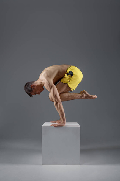 Yoga keeps balanc on hands in difficult pose - Φωτογραφία, εικόνα
