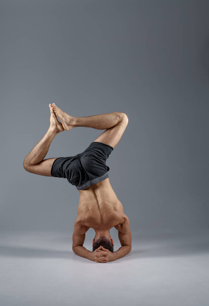 Męska joga stojąca na jego głowie i łokciach - Zdjęcie, obraz