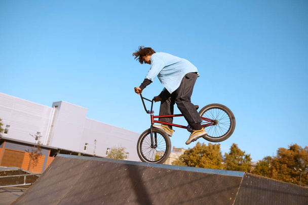 Bmx biker doing trick on ramp in skatepark - Photo, Image