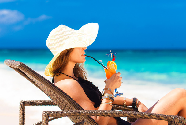 young woman in straw hat laying at the tropical beach and enjoyi - Foto, imagen
