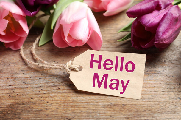 Beautiful spring tulips and label with text Hello May on wooden background - Fotó, kép