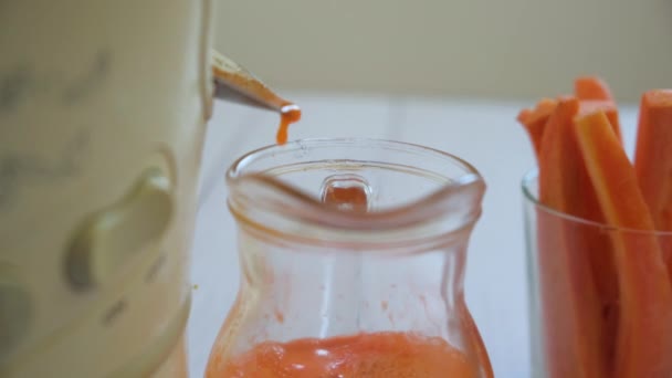 Подготовка морковного сока в соковыжималке. Крупный план - Кадры, видео