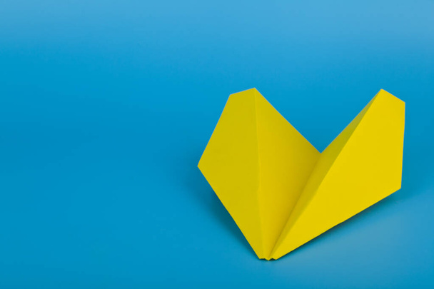 Flat lay of yellow paper plane and blue background.Travel concept mockup.Horizontal. - Fotó, kép