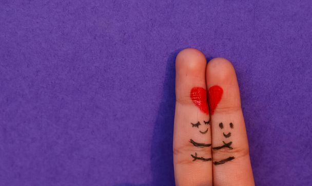 Fondo del Día de San Valentín, Una feliz pareja enamorada de sonriente pintado y abrazando el arte en el dedo. Concepto de San Valentín con fondo púrpura aislado con espacio. - Foto, Imagen