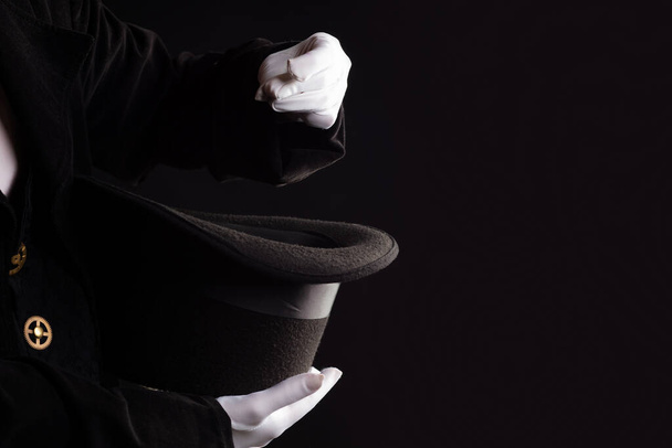 Hand gestures. Showman shows disappearing tricks in a hat, white gloves and black top hat, - 写真・画像