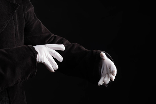 Hand gestures. Showman or magician illusionist in white gloves on a black background. - Fotoğraf, Görsel