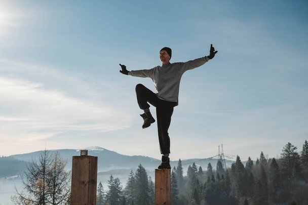 Man practicing yoga and balancing exercises in the winter mountains and enjoying life. Copy, empty space for text. - Photo, Image