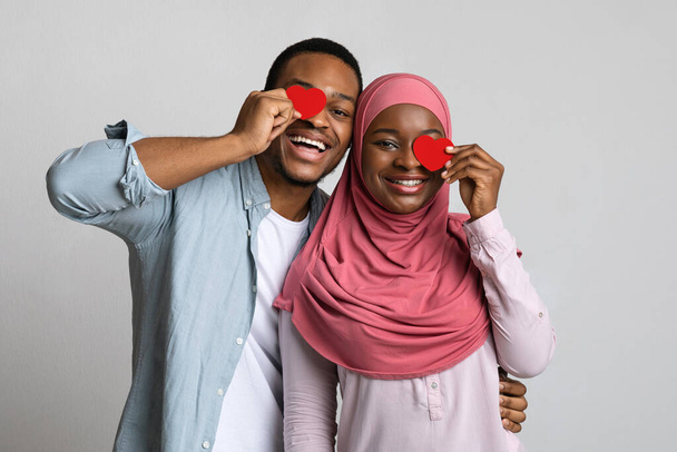 Giocosi amanti neri che coprono un occhio con cuori rossi - Foto, immagini