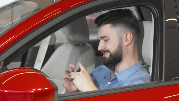 Handsome happy man showing keys to his new car - Footage, Video