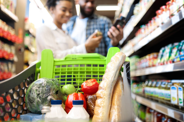 Compras de comestibles de familia negra en el supermercado, enfoque en el carrito - Foto, imagen