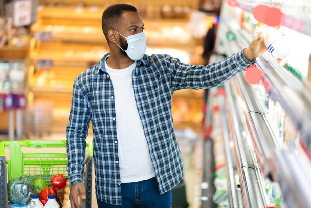 Афроамериканец в маске для лица в супермаркете - Фото, изображение