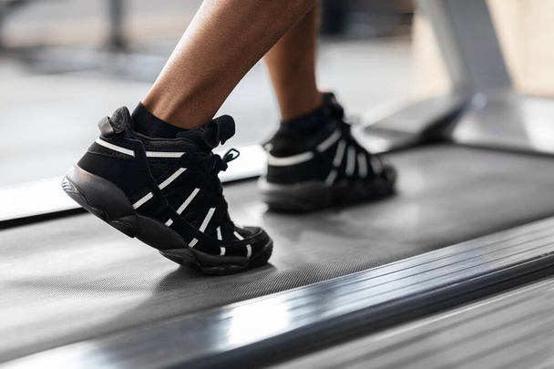 Primeros planos del hombre negro caminando por las zapatillas de treadmill - Foto, Imagen