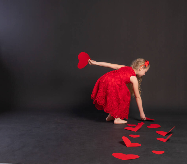 paper hearts love symbol, valentines board, on the floor hearts married space. February 14, the honeymoon. a gift in a red dress girl, barefoot - Foto, immagini