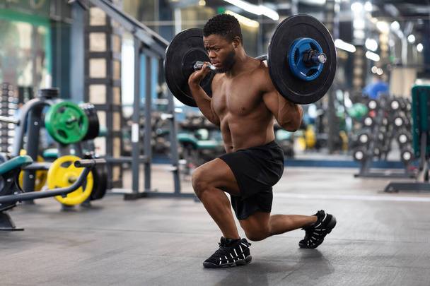 Shirtless black guy sportsman making squats with barbell - Photo, Image